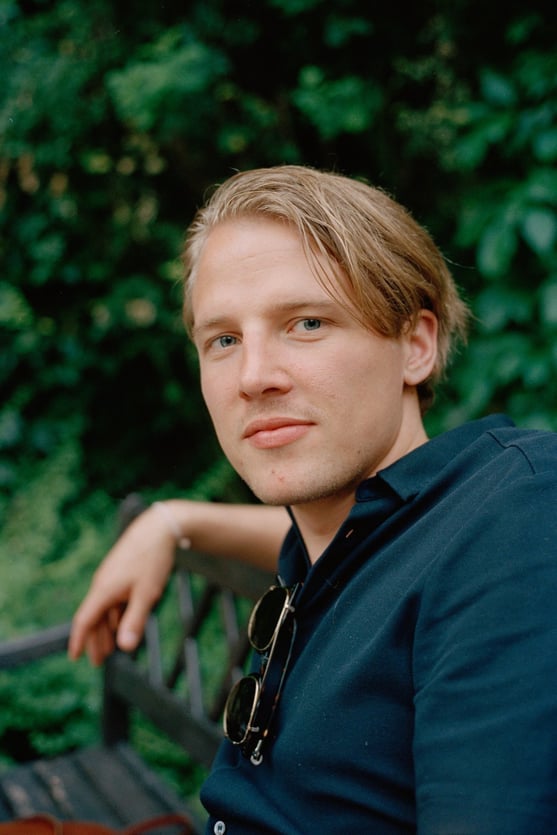 young blond man looking into camera